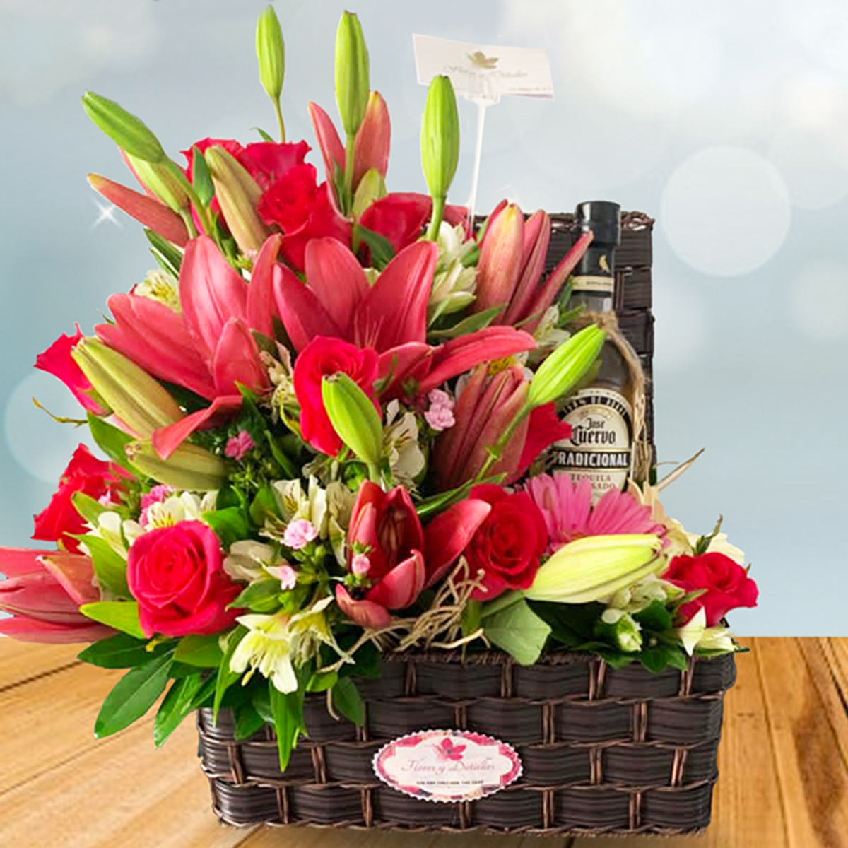 Baúl con 10 lilis, 24 rosas, 3 gerberas y una botella de tequila josé cuervo