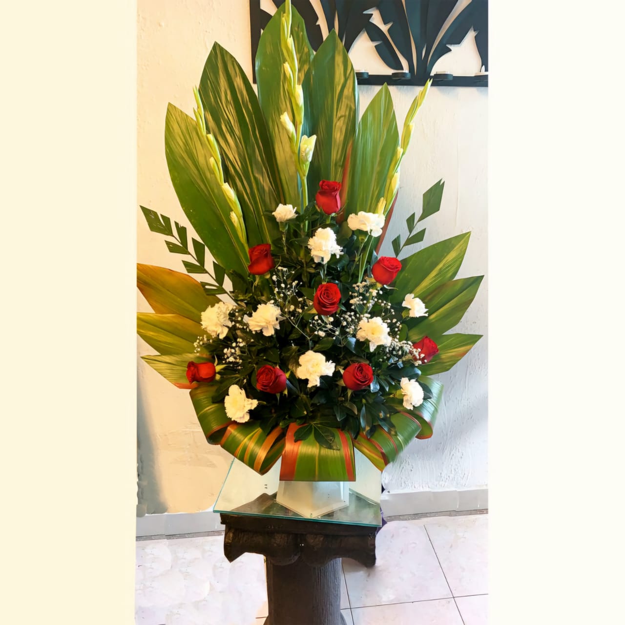 Ofrenda ﬂoral con Gladiolas,  rosas y claveles.